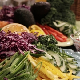 Strimlade grönsaker av all de slag i en färgrik mix på tallrik.
