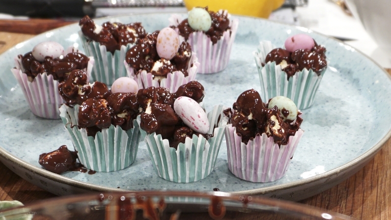 Tallrik med små formar i pastellfärger fyllda med choklad och chokladägg.