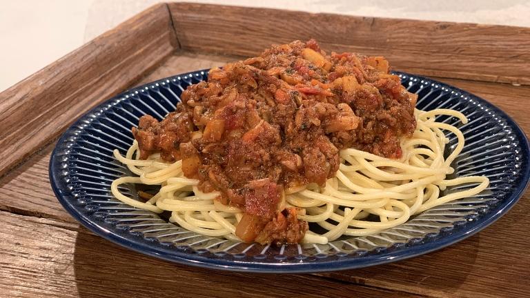 Köttfärssås och spaghetti på en blå tallrik.