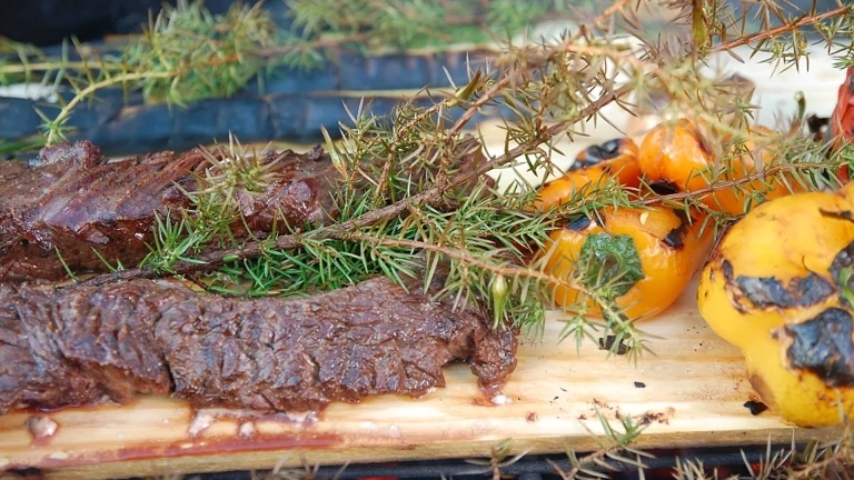 Köttbitar på planka med enris och grillad gul paprika. 