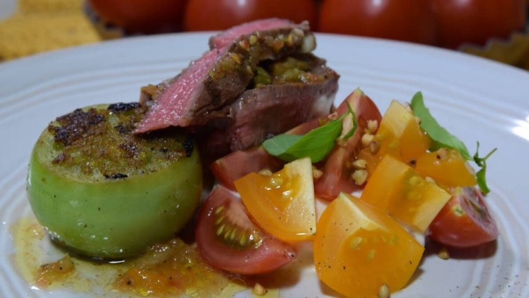 Tallrik med stekt grön tomat, tomatsallad, kött och vinägrett.