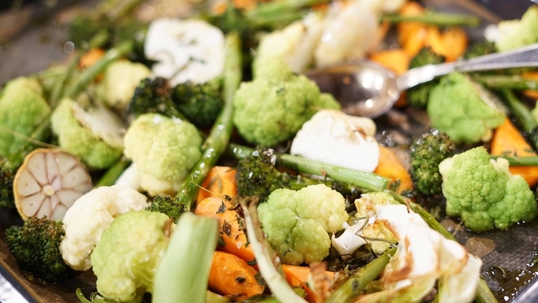 En ugnsbricka med nyrostade grönsaker: broccoli, sparris, vitlök, morötter, blomkål. Sprinklad med timjan och flingsalt. 