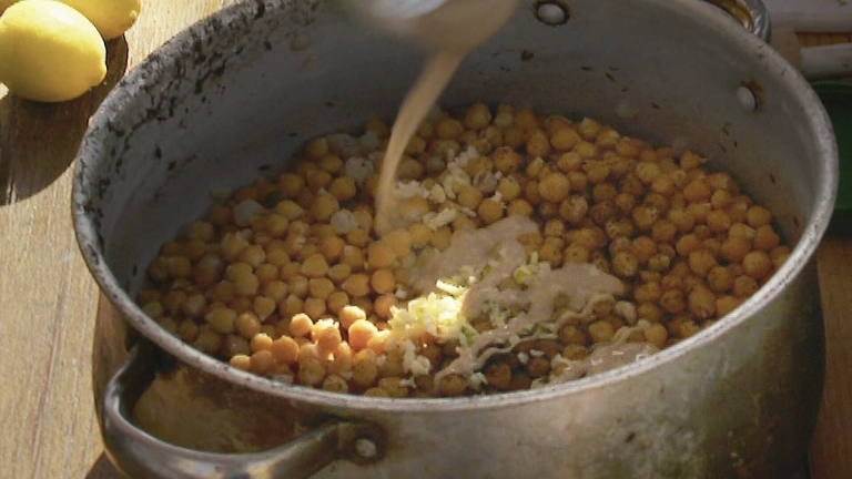 En stor kastrull med kikärtor och tahini, ingredienserna till hummus. 