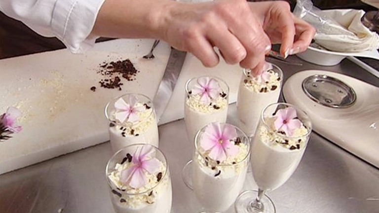 Sex glas med dessert på en köksbänk 