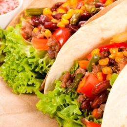 Två stora tacos med bröd fyllda med köttfärs och bönor och majs och sallad. 